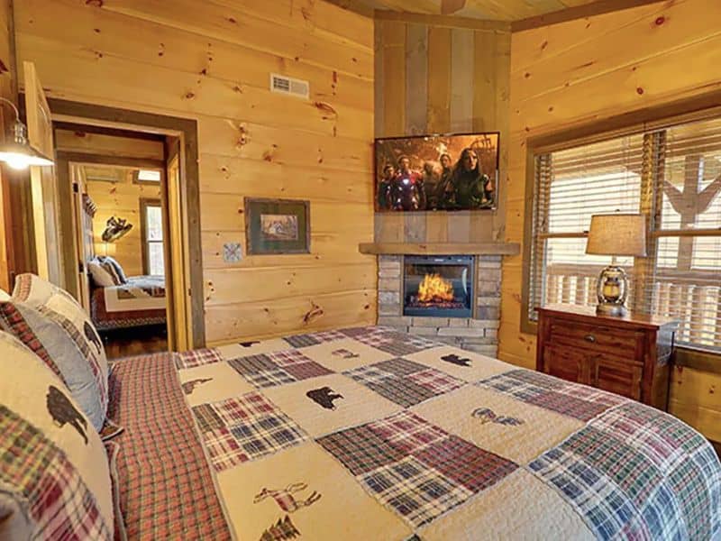 Bedroom in Gatlinburg cabin rental with in-room fireplace and quilted bed