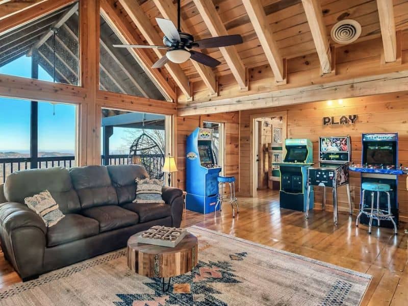 Living area in vrbo cabin in Gatlinburg with vaulted ceilings and large floor to ceiling windows