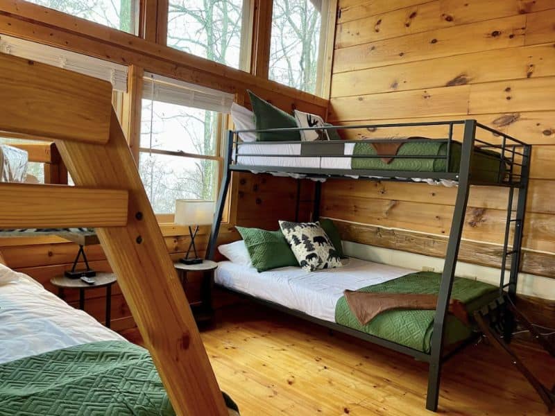 Bunk room in large cabin rental in Gatlinburg with wood finishes and green accents