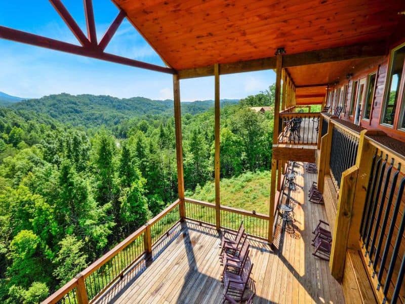 Smoky Mountain views as soon from a large covered deck with seating - property is featured in a guide to the best large cabin rentals in Gatlinburg