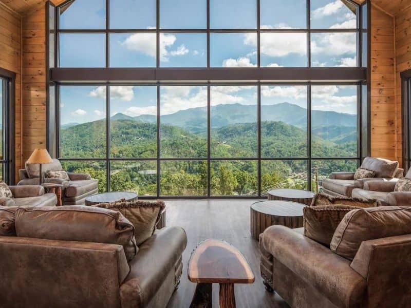 Large living room with floor to ceiling windows overlooking the Great Smoky Mountains - large cabin rentals in Gatlinburg, TN