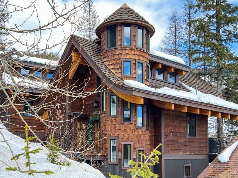 A ski in ski out chalet with snow on the roof in Whitefish Montana.