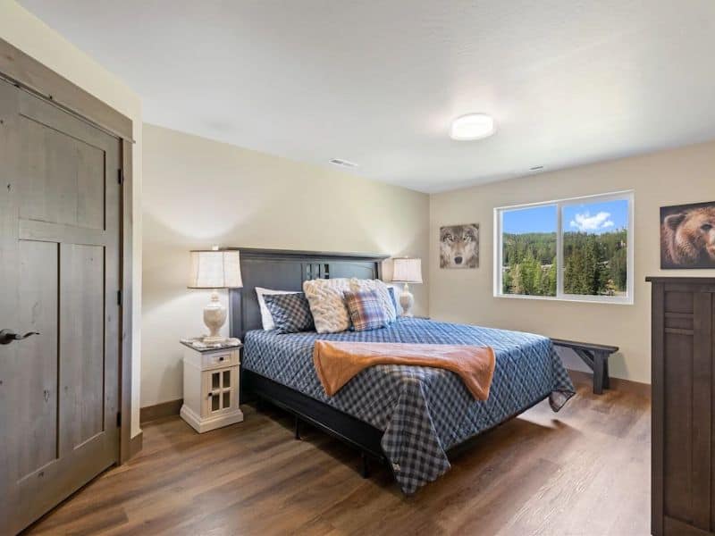 A bedroom in a Whitefish MT vacation home with hardwood floors and a comfortable bed.