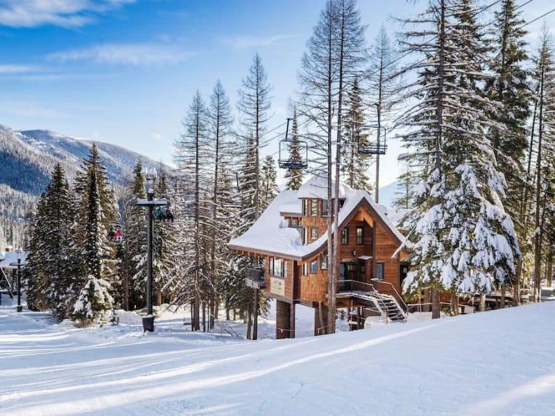 A ski in ski out chalet on a slope in Whitefish, MT with a ski lift passing right overhead.