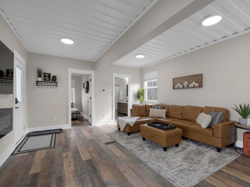 A cabin in Hocking Hills with a living room featuring hardwood floors and a fireplace.