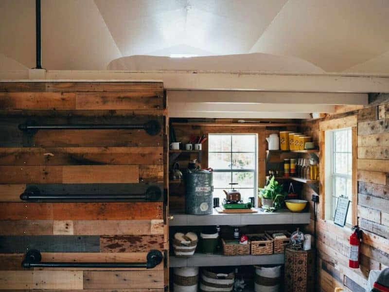 Compact and functional kitchenette in a cozy cabin in the Catskills, with reclaimed wood shelves, essential cookware, and a warm, inviting atmosphere.