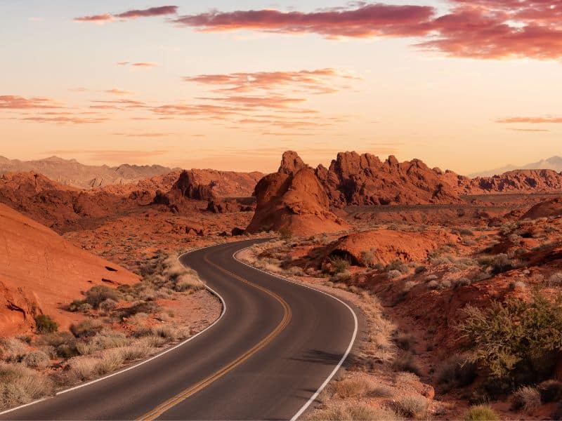 Valley of Fire, Nevada at dusk with a highway running through the middle of it.