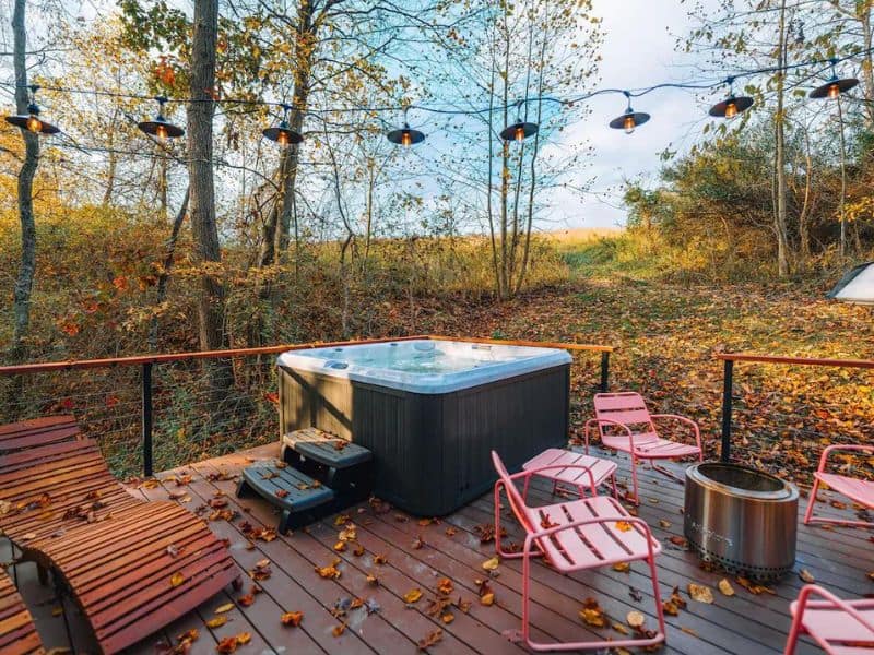 Outdoor deck of The Ellwood featuring a hot tub and string lights. Hocking Hills, OH.