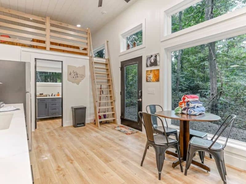 Bright and airy kitchenette with a ladder to a loft, inside The Nook, a cozy container cabin in Hocking Hills, Ohio.