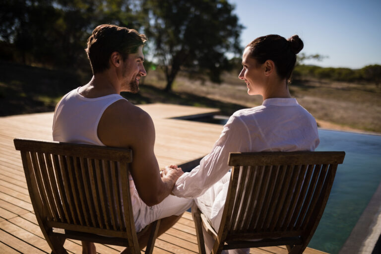 Romantic couple sitting together on chair at safari vacation