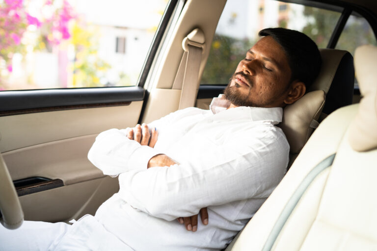 tired cab driver resting or sleeping by pushing car seat during break time - concept of overworked, exhausted and low business or no passengers.
